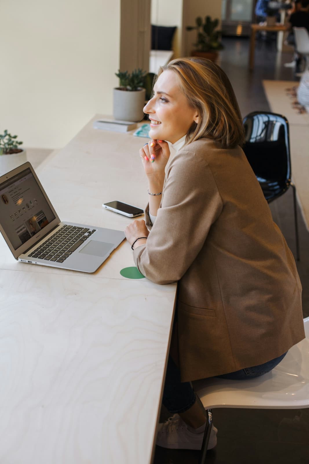 Woman reflecting at a laptop